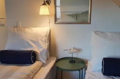 a living room with a couch and a table at Centralt by hus Blokhus-Hune til 10 pers privat Gårdhave in Blokhus