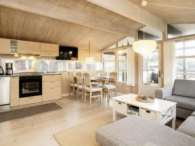 a kitchen and living room with a table and chairs at Tranquil Beach Retreat - By Traum Ferienwohnungen in Løkken