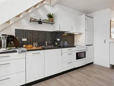 a white kitchen with white cabinets and appliances at Apartment Milly - 150m to the fjord by Interhome in Vestervig