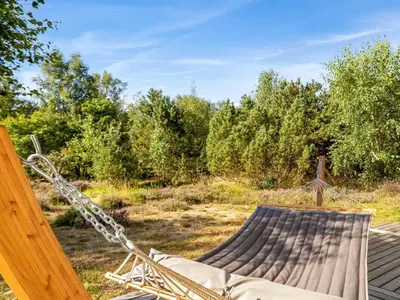 a hammock on a deck with a field and trees at Holiday Home Guri - 600m to the fjord by Interhome in Fur