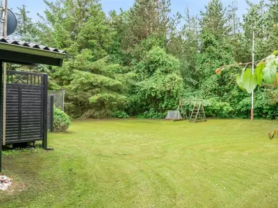 a large yard with a playground in the background at Holiday Home Suri - 200m to the fjord by Interhome in Thyholm
