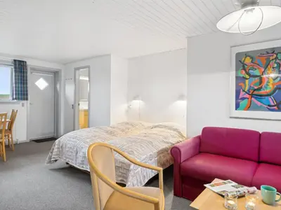 a bedroom with a bed and a purple couch at Holiday Home Annli - 800m to the fjord by Interhome in Fur