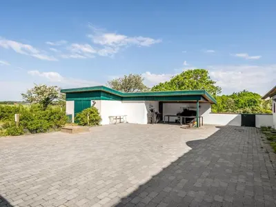 a white building with a green roof and a patio at Holiday Home Annli - 800m to the fjord by Interhome in Fur