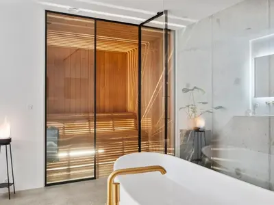 a bathroom with a glass shower with a tub at Holiday Home Ilja - 800m from the sea by Interhome in Blokhus
