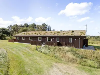 a barn with a grass roof on a field at Holiday Home Joris - 1-5km from the sea by Interhome in Løkken