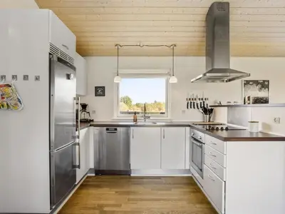 a kitchen with stainless steel appliances and a window at Holiday Home Joris - 1-5km from the sea by Interhome in Løkken