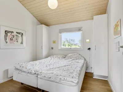 a bedroom with a bed in a room with a window at Holiday Home Joris - 1-5km from the sea by Interhome in Løkken