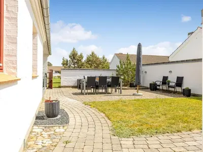 a patio with tables and chairs in a backyard at Holiday Home Leny - 900m from the sea by Interhome in Pandrup