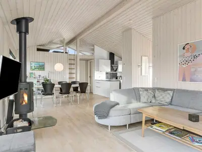 a living room with a couch and a fireplace at Holiday Home Mirla - 50m from the sea by Interhome in Saltum