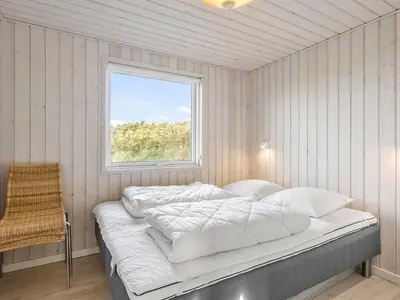 a bed in a room with a window at Holiday Home Mirla - 50m from the sea by Interhome in Saltum