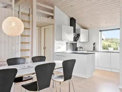 a kitchen and dining room with a table and chairs at Holiday Home Mirla - 50m from the sea by Interhome in Saltum