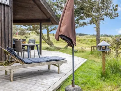 a patio with a table and an umbrella on a deck at Holiday Home Lagho - 500m from the sea by Interhome in Pandrup