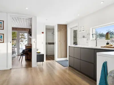 a kitchen with white walls and wooden floors at Holiday Home Lagho - 500m from the sea by Interhome in Pandrup