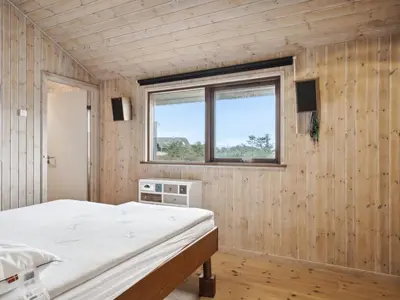 a bedroom with a bed and a window at Holiday Home Gidske - 300m from the sea by Interhome in Blokhus