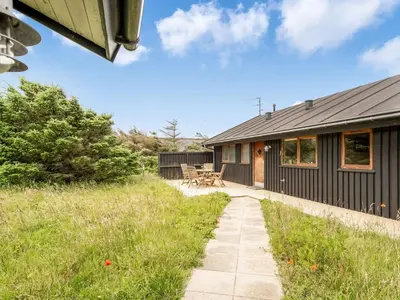 a house with a patio next to a building at Holiday Home Gidske - 300m from the sea by Interhome in Blokhus