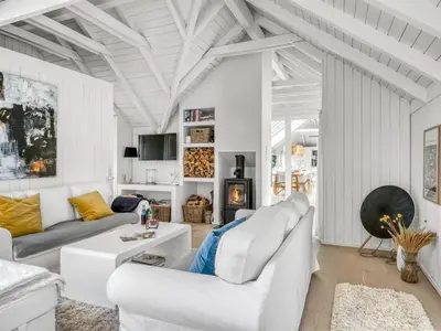 a living room with white furniture and a fireplace at Holiday Home Verner - 900m from the sea by Interhome in Fjerritslev