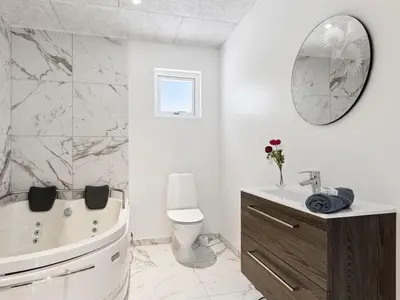 a bathroom with a tub and a toilet and a sink at Holiday Home Scalli - 1-5km to the fjord by Interhome in Farsø
