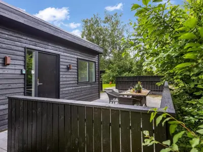 a backyard with a wooden fence and a table at Holiday Home Scalli - 1-5km to the fjord by Interhome in Farsø