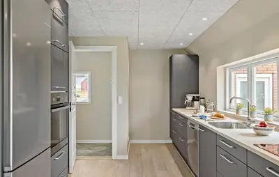 a kitchen with stainless steel appliances and gray cabinets at Nice Home In Thyholm With Wifi in Thyholm