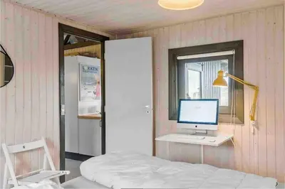 a bedroom with a desk with a computer and a window at Veludstyret sommerhus i unik natur 350 m fra lækker badestrand - helårsbolig in Saltum