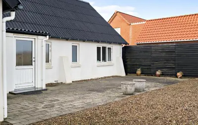 a white house with a black roof and two buildings at Amazing Home In Harboøre With Kitchen in Harboør