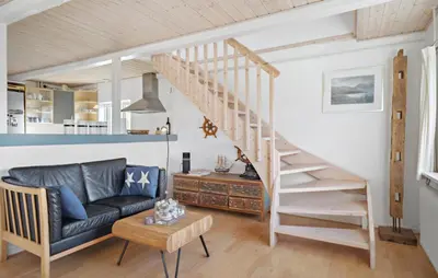 a living room with a couch and a staircase at Amazing Home In Harboøre With Kitchen in Harboør