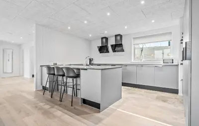 a kitchen with white cabinets and black bar stools at Stunning Home In Løgstrup With Kitchen in Løgstrup