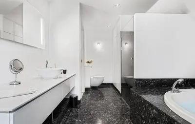 a bathroom with two sinks and a tub and a toilet at Amazing Home In Blokhus With Kitchen in Blokhus