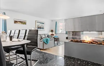 a living room with a fireplace and a table at Amazing Home In Blokhus With Kitchen in Blokhus