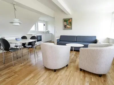 a living room with a couch and tables and chairs at Holiday Home Mirja - 50m to the fjord by Interhome in Fur