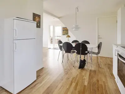 a kitchen with a white refrigerator and a table with chairs at Holiday Home Mirja - 50m to the fjord by Interhome in Fur
