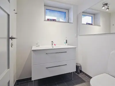 a bathroom with a white sink and two windows at Holiday Home Mirja - 50m to the fjord by Interhome in Fur