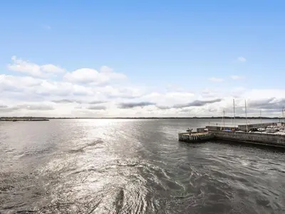 a large body of water with a pier and boats at Holiday Home Mirja - 50m to the fjord by Interhome in Fur