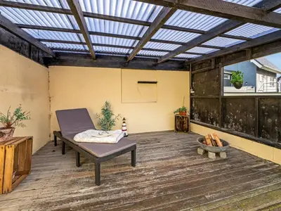 a patio with a bench on a wooden deck at Holiday Home Ullakarin - 200m from the sea by Interhome in Thyborøn