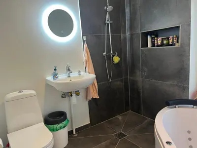 a bathroom with a sink and a toilet and a shower at Nice small house 5 minutes to the sea in Ranum