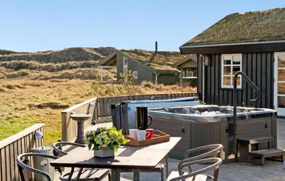 a deck with a hot tub and a table with chairs at 4 Bedroom Beautiful Home In Pandrup in Pandrup
