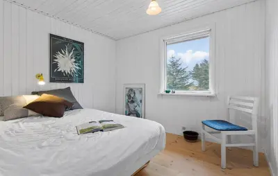 a bedroom with a bed and a chair and a window at Awesome Home In Brovst With Wifi in Brovst