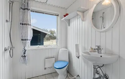 a bathroom with a toilet and a sink and a mirror at Awesome Home In Brovst With Wifi in Brovst