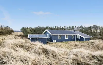 a blue house in the middle of a field at Awesome Home In Brovst With Wifi in Brovst