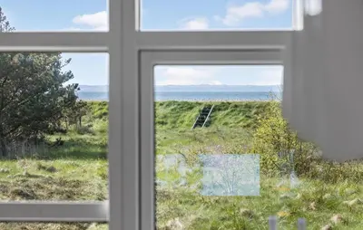 a window with a view of a field and the ocean at Nice Home In Hurup Thy With Wifi in Sindrup