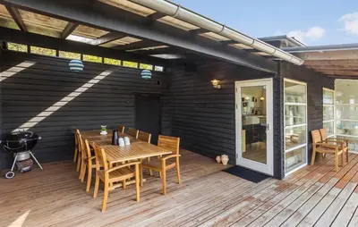 a wooden deck with a wooden table and chairs at Nice Home In Hurup Thy With Wifi in Sindrup