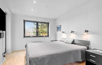 a white bedroom with a bed and a window at Amazing Home In Roslev With Sauna in Roslev