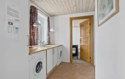 a laundry room with a sink and a washing machine at Cozy Home In Frøstrup With Sauna in Frøstrup