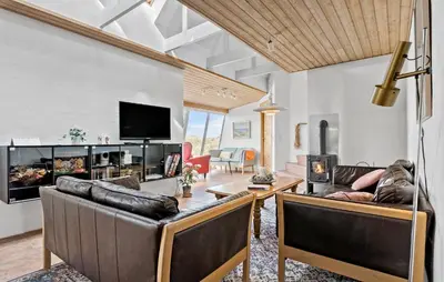 a living room with leather couches and a tv at Cozy Home In Frøstrup With Sauna in Frøstrup