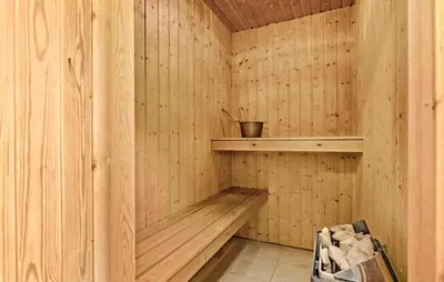 a wooden sauna with a wooden bench in it at Cozy Home In Frøstrup With Sauna in Frøstrup
