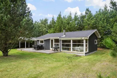 a small house with a deck and a patio at Little Fiskerbanke - Lovely, Private, And Family-Friendly Holiday Home in Saltum