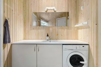 a bathroom with a washing machine and a sink at Little Fiskerbanke - Lovely, Private, And Family-Friendly Holiday Home in Saltum