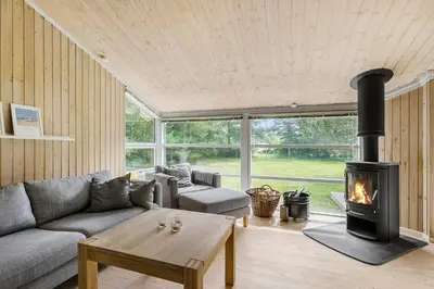 a living room with a couch and a fireplace at Little Fiskerbanke - Lovely, Private, And Family-Friendly Holiday Home in Saltum