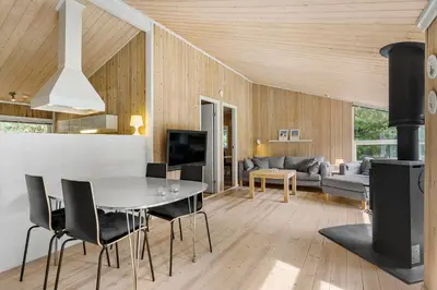 a living room with a table and a fireplace at Little Fiskerbanke - Lovely, Private, And Family-Friendly Holiday Home in Saltum