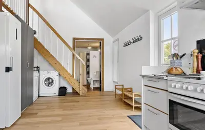 a white kitchen with a staircase and a washing machine at Pet Friendly Apartment In Vestervig in Vestervig
